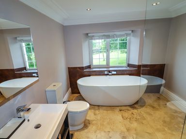 A bathroom with a bathtub toilet sink and a window at The Manor House Skerry Vore Bryn Pydew near Llandudno Junction