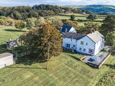 A house with a pool and outdoor seating in a grassy area at The Manor House Skerry Vore Bryn Pydew near Llandudno Junction