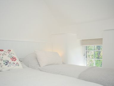 A bedroom with two beds next to a window at Sunrise Cottage in St Kew Highway near Wadebridge
