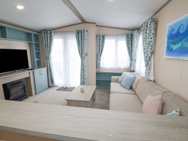 A living room with a sofa a coffee table a television and windows with curtains at The Mermaid A04 in Par