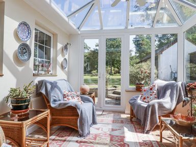 A conservatory with sofas and plants at Temple House in Goonhavern