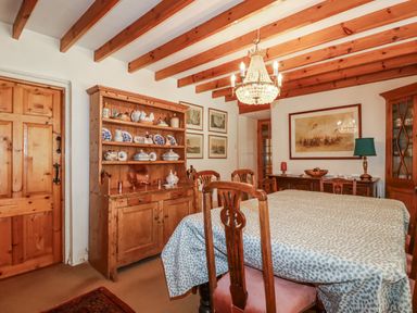 A dining room with a table and sideboard at Temple House in Goonhavern