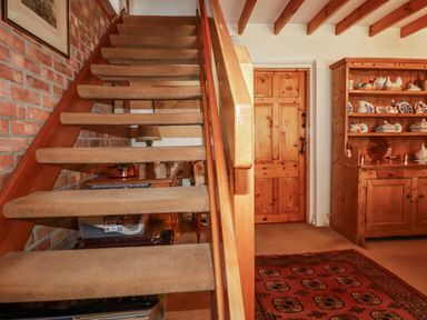 A staircase and wooden door in a hallway at Temple House in Goonhavern