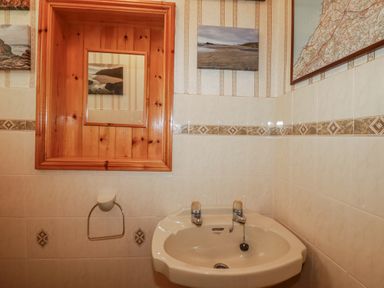 A bathroom with a sink and wall art at Temple House in Goonhavern