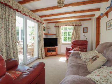 A living room with a sofa and television at Temple House in Goonhavern
