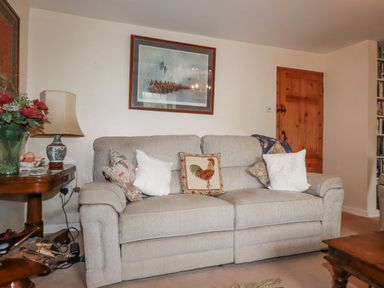 A living room with a sofa and a table at Temple House Goonhavern