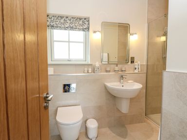A bathroom with a toilet sink mirror and shower at Strawberry Cottage in Wester Essendy near Dunkeld