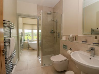 A bathroom with a glass shower enclosure a toilet a sink and a bathtub near a window at Bramble Cottage in Wester Essendy near Dunkeld