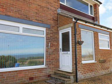 Front entrance of a brick house with white door and windows with reflections at 315 Filey Road Scarborough