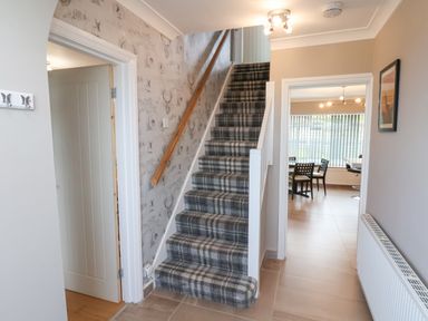 A hallway with carpeted stairs between two doorways leading to other rooms at 315 Filey Road Scarborough