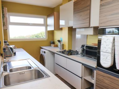 A kitchen with a stainless steel sink stove microwave washing machine and cabinets at 315 Filey Road in Scarborough