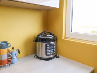 A kitchen corner with a pressure cooker a set of stacked mugs and a stovetop espresso maker on a countertop at 315 Filey Road Scarborough