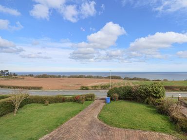 A driveway leading to a road with fields and sea beyond at 315 Filey Road in Scarborough