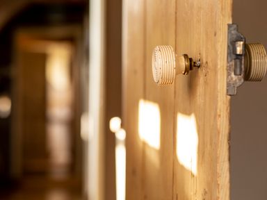 A wooden door with a vintage ceramic doorknob in a hallway at Brook Farm in St Nicholas near Halesworth