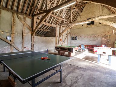 A recreational room with a ping pong table billiards table and foosball table at Brook Farm in St Nicholas near Halesworth