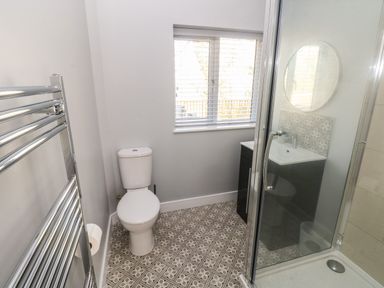 A bathroom with a toilet sink shower and towel radiator at Wychwood in Hook near Haverfordwest