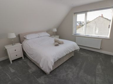 A bedroom with a double bed with white bedding two bedside tables with lamps and a window with blinds at Wychwood in Hook near Haverfordwest