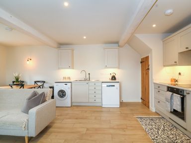 A kitchen with sofa and dining table with chairs at 8 Rookhaye in Salisbury