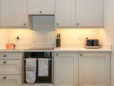 A kitchen countertop with a knife block microwave and oven at 8 Rookhaye in Salisbury