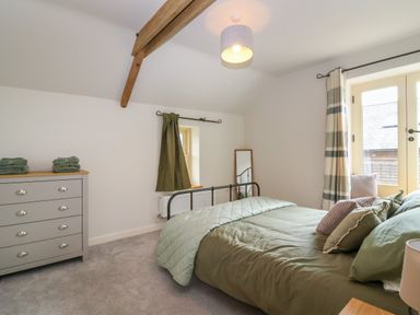 A bedroom with a bed pillow and blanket chest of drawers and curtains at 8 Rookhaye in Salisbury