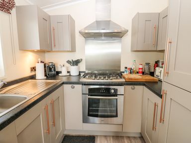 A kitchen with a gas stove oven range hood sink cabinets and kitchen utensils at Plot 32 High Hesket near Armathwaite