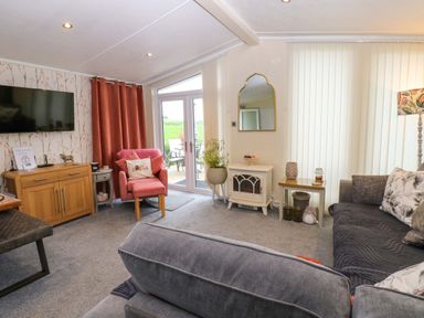A living room with a television and sofa at Plot 32 in High Hesket near Armathwaite