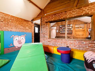 A playroom with soft climbing blocks and a wall with a painted pig at Widgeon in Wheatacre