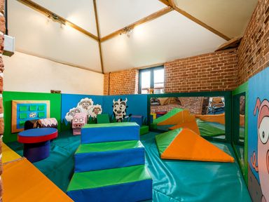 A playroom with soft foam blocks and animal murals on the walls at Teal in Wheatacre