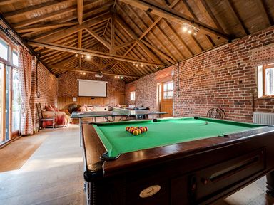 A games room with a pool table ping pong table sofas and exposed brick walls at Teal in Wheatacre