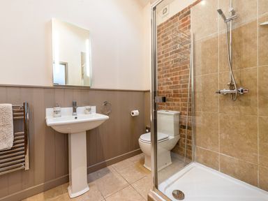 A bathroom with a pedestal sink mirror shower enclosure and toilet at Partridge in Wheatacre