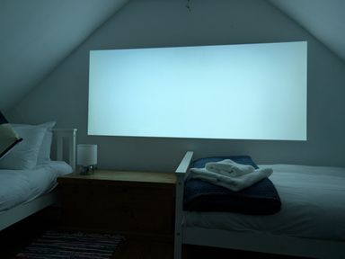 A bedroom with two single beds a wooden chest a lamp and towels on one bed at Georgian Hideaway in Weymouth