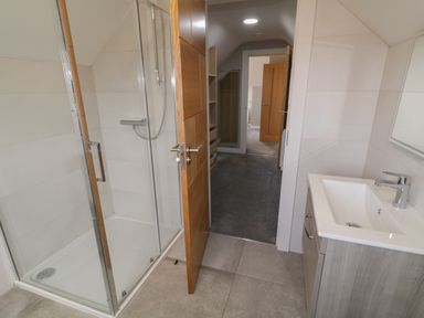 A bathroom with a glass shower enclosure and a sink with a faucet at Moorhen House in Loughanure near Annagry County Donegal