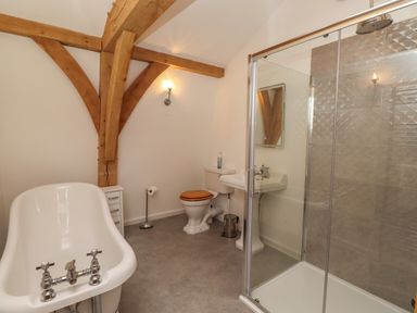 A bathroom with a bathtub toilet sink and glass shower enclosure at The Boathouse in Belford