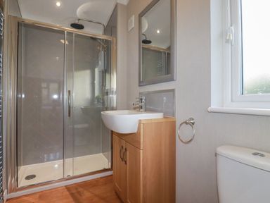 A bathroom with a shower enclosure sink with cabinet mirror towel ring and a window at 6 Faraway Fields in Dobwalls