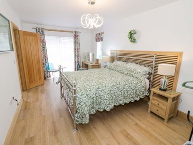 A bedroom with a bed and bedside table at The Barn in Astwood Bank