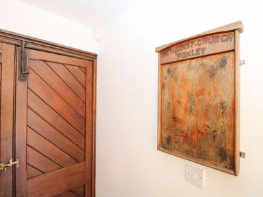 A wooden door and an old wooden board with Methodist Church Foxley inscription on a wall at The Old Chapel in Foxley near Bawdeswell
