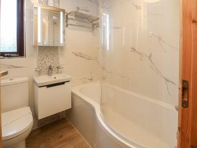 A bathroom with a toilet sink bathtub and towel rack at Moonlake Lodge in Woolsery near Woolfardisworthy