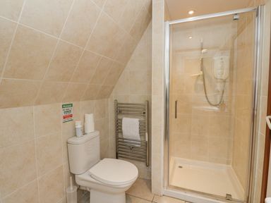 A bathroom with a toilet and a glass-enclosed shower at Lodge 2 - Inglewood Lodge in Spean Bridge