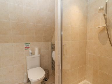 A bathroom with a toilet shower and towel rack at Lodge 2 - Inglewood Lodge in Spean Bridge