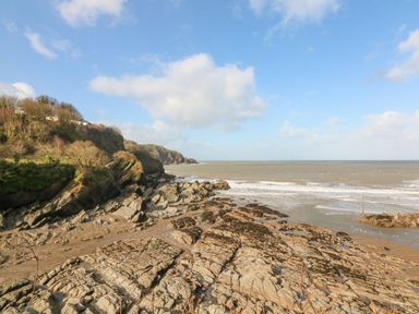 A rocky coastline with cliffs and waves at 18 Manleigh Park in Combe Martin