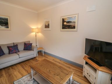 A living room with a sofa and a television at No 1 Lodge Wood, Kenmare, County Kerry