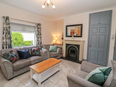 A living room with sofas and a fireplace at No 1 Lodge Wood in Kenmare, County Kerry