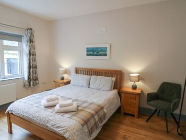 A bedroom with a bed and nightstands at No 1 Lodge Wood, Kenmare, County Kerry