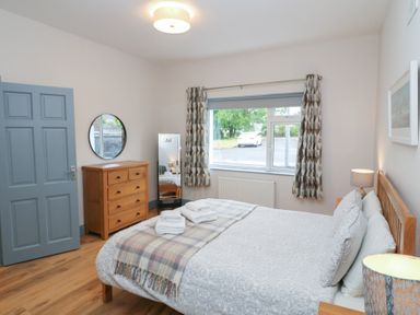 A bedroom with a bed and a dresser at No 1 Lodge Wood in Kenmare, County Kerry