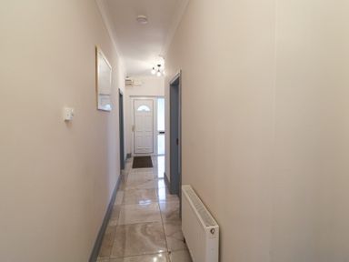 A hallway with a front door and mirror at No 1 Lodge Wood, Kenmare, County Kerry