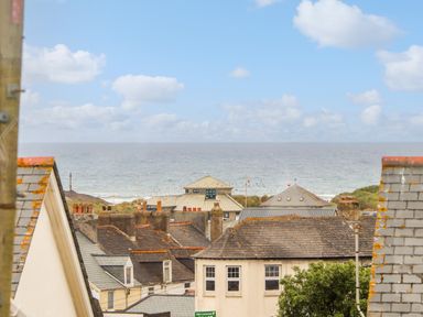 Rooftops of houses with a view of the sea and sky at Cobblestone Cottage in Bude