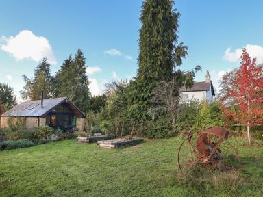 An outdoor area with a cottage, garden, and trees at The Cart Shed in Barwick near Yeovil, Somerset