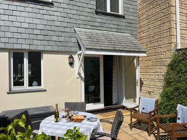 An outdoor patio with a table and chairs at Breeze Cottage in Falmouth