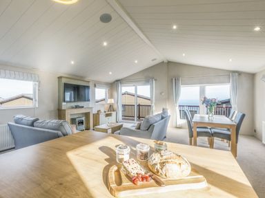 A living room with a television and a dining area at Lodge 66 at Riviera Bay Coastal Retreat Brixham