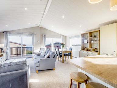 A living room with a sofa and dining table at Lodge 55 at Riviera Bay Coastal Retreat Brixham